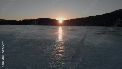 The beautiful sunset colors of sunset over the frozen lake in North Hatley in Canada - aerial photo