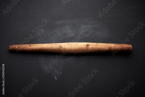 very old wooden rolling pin for rolling dough on a black background