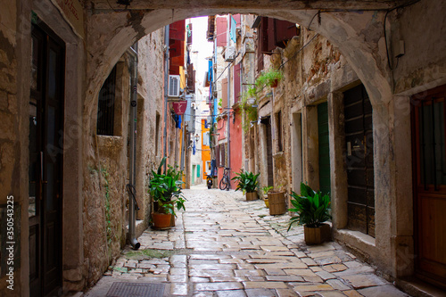 Picturesque arch with a colorful street at the background in the old town of Rovinj, Croatia