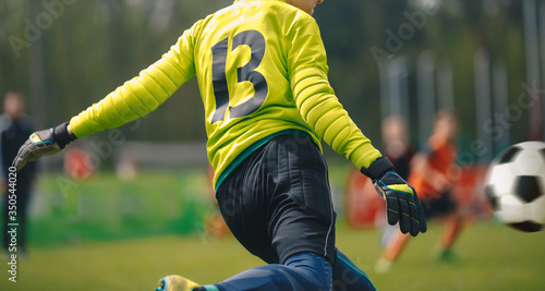 Goal kick by soccer junior level goalie. Football goalkeeper kick during competition match © matimix