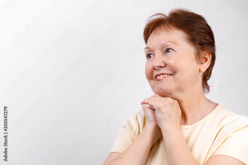 close-up portrait, face of a beautiful senior woman looking to the side on a white background in a light T-shirt. place for text. isolated close-up portrait, face of a beautiful senior woman looking to the side on a white background in a light T-shirt. place for text. isolated