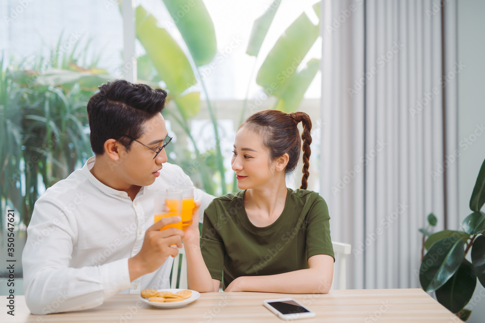 Happy young asian couple making organic drink together. Happy young asian couple making organic drink together.