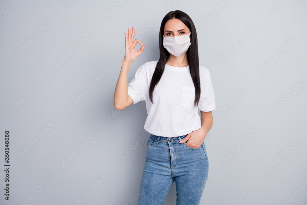 Portrait of confident cool girl enjoy corona virus safety protection respiratory mask approve quality show okay sign wear white t-shirt denim isolated over gray color background Portrait of confident cool girl enjoy corona virus safety protection respiratory mask approve quality show okay sign wear white t-shirt denim isolated over gray color background