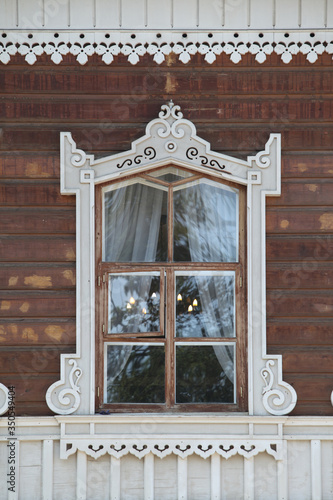 Ornamental window with carved frame on Sukachyov's wooden house, Irkutsk city, Russia. Museum-estate of V. P. Sukachev. Russian folk style in Irkutsk architecture photo