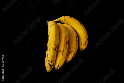 Принти на полотні Some beautiful bananas on a black studio background.