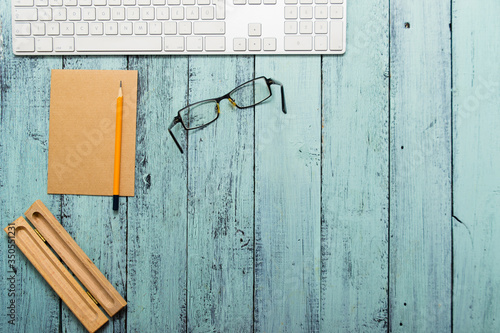 keypad, eyeglasses, recycled note paper on blue wooden table, top view