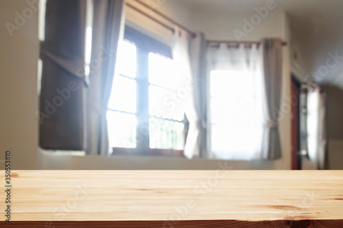 Empty wooden desk space over curtain and window background for product presentation.