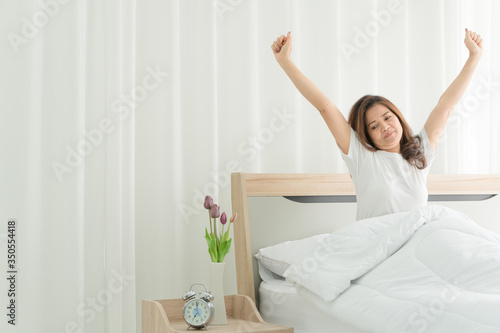 Senior Asian woman wakes up And doing stretching exercises