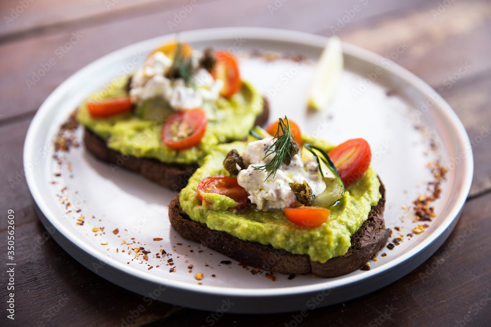 Smashed avocado toasts on rye bread.