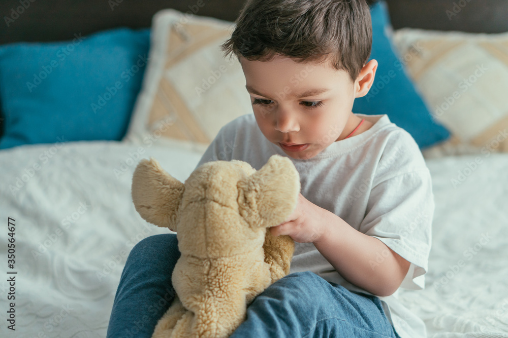 cute toddler kid looking at soft toy in bedroom cute toddler kid looking at soft toy in bedroom
