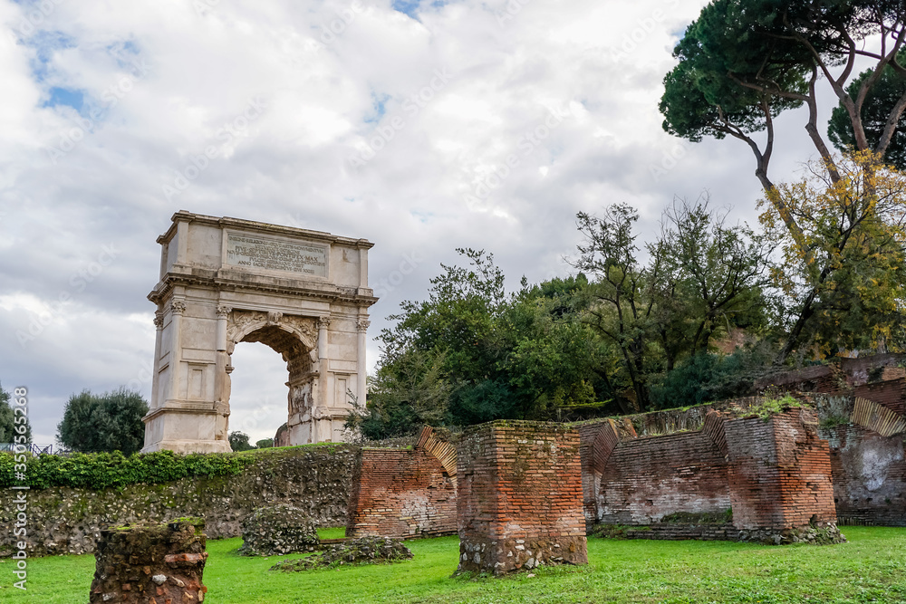 Fototapeta premium green trees near ancient arch of titus in rome
