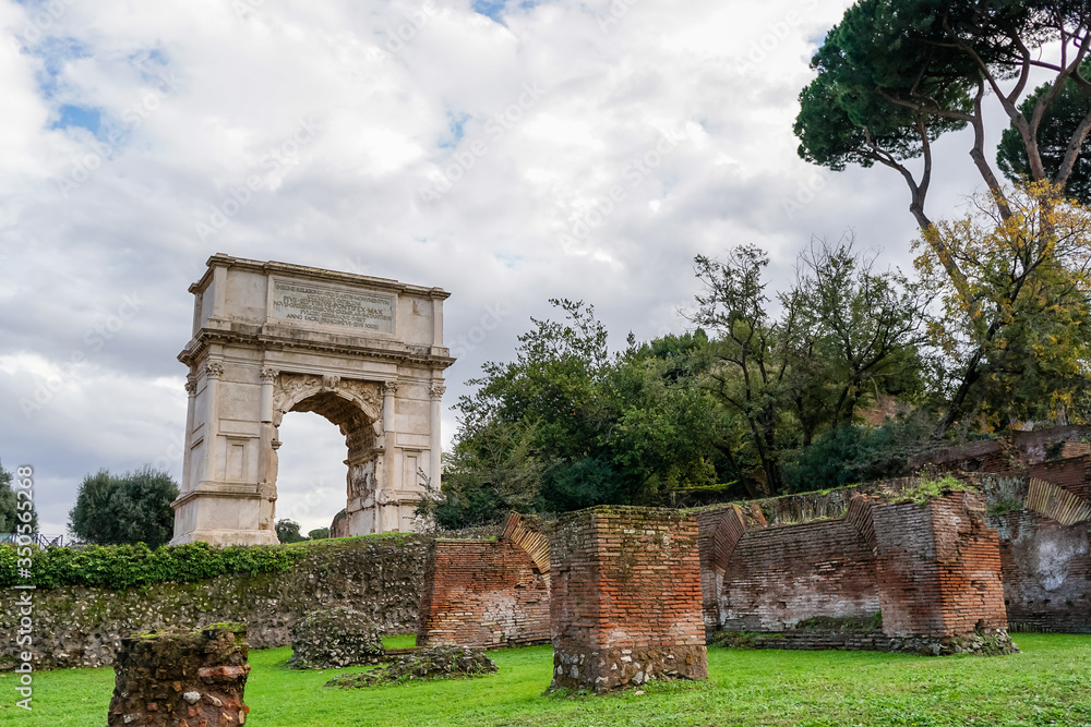 green trees near ancient arch of titus in rome