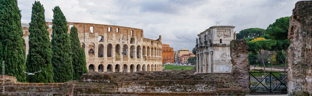 panoramic crop of ancient colosseum near historical buildings