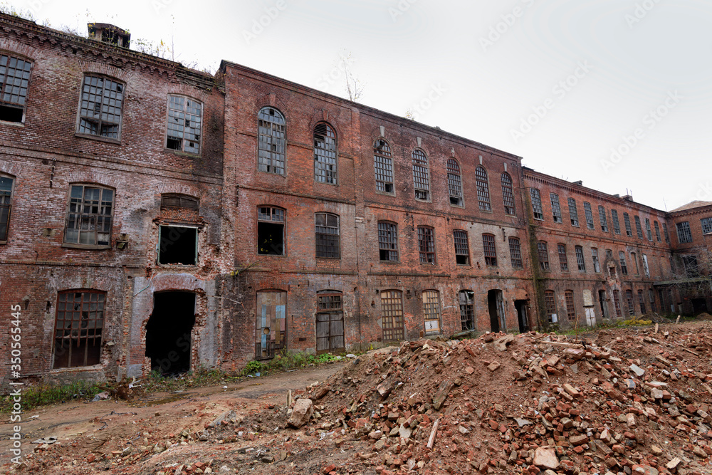 old abandoned factory. The ruined building of a red brick textile factory. European part of Russia.