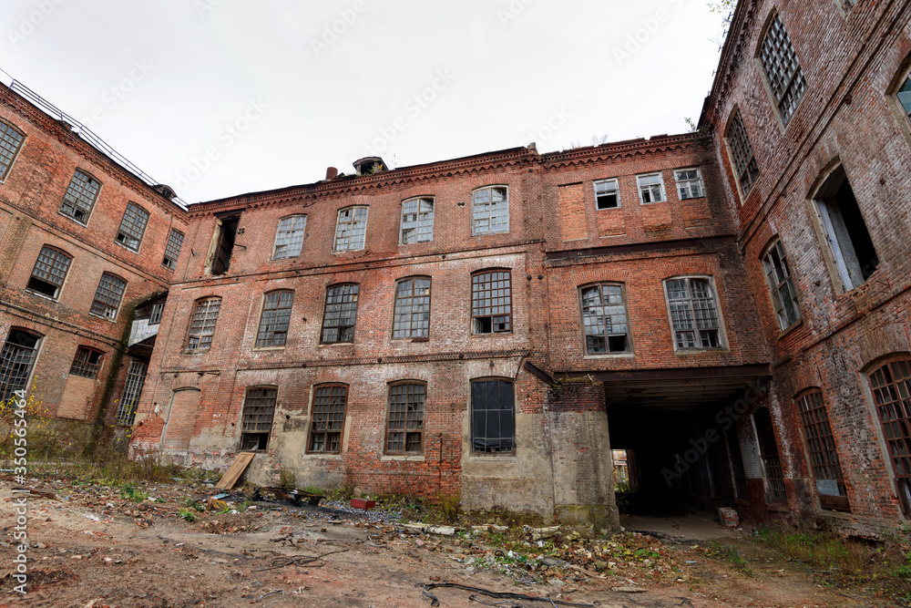 old abandoned factory. The ruined building of a red brick textile factory. European part of Russia. old abandoned factory. The ruined building of a red brick textile factory. European part of Russia.