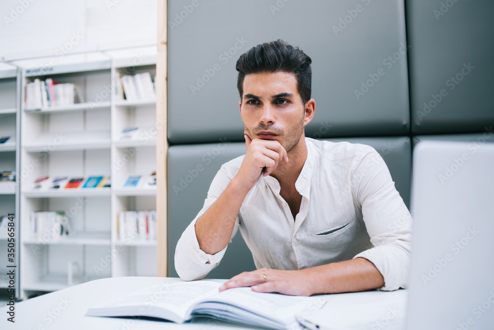 Focused man using book in library