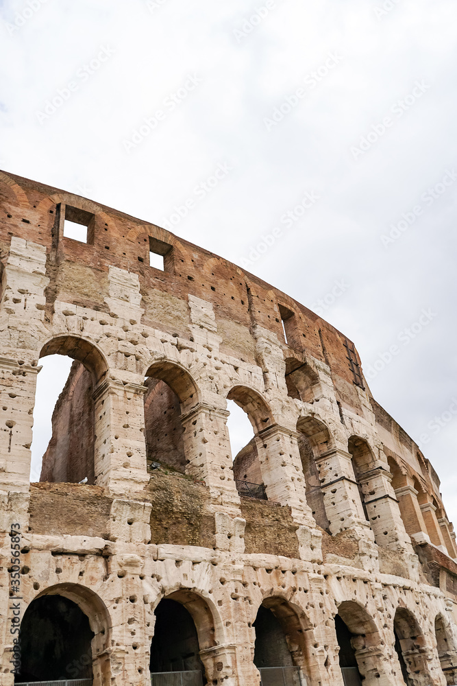 ancient Colosseum against cloudy sky in rome