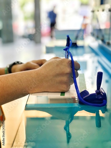 The right hand is holding the pen in order that filling the information form is completed which is on the table.