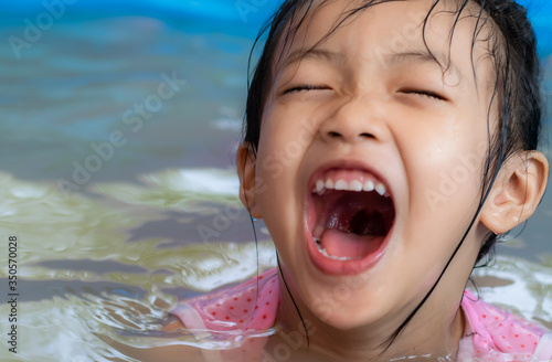 Kindergarten girls in Asia play in the inflatable pool.