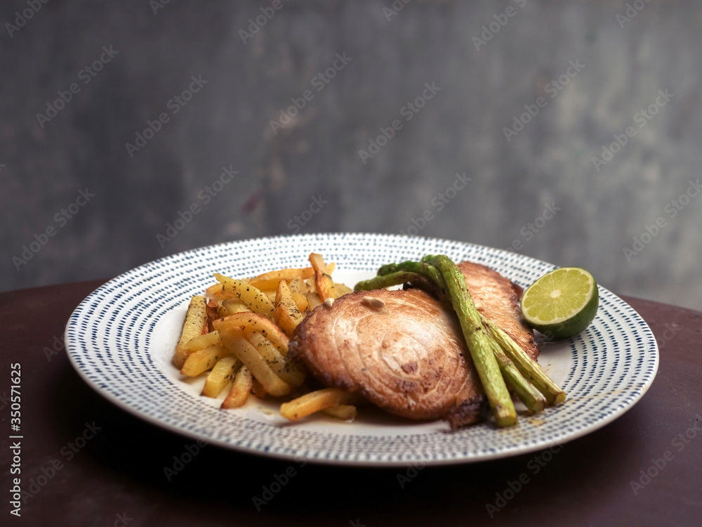 Fish and chips. Tuna steak, asparagus, fried potatoes and fried eggs on a white plate. English traditional dish. Fish and chips. Tuna steak, asparagus, fried potatoes and fried eggs on a white plate. English traditional dish.