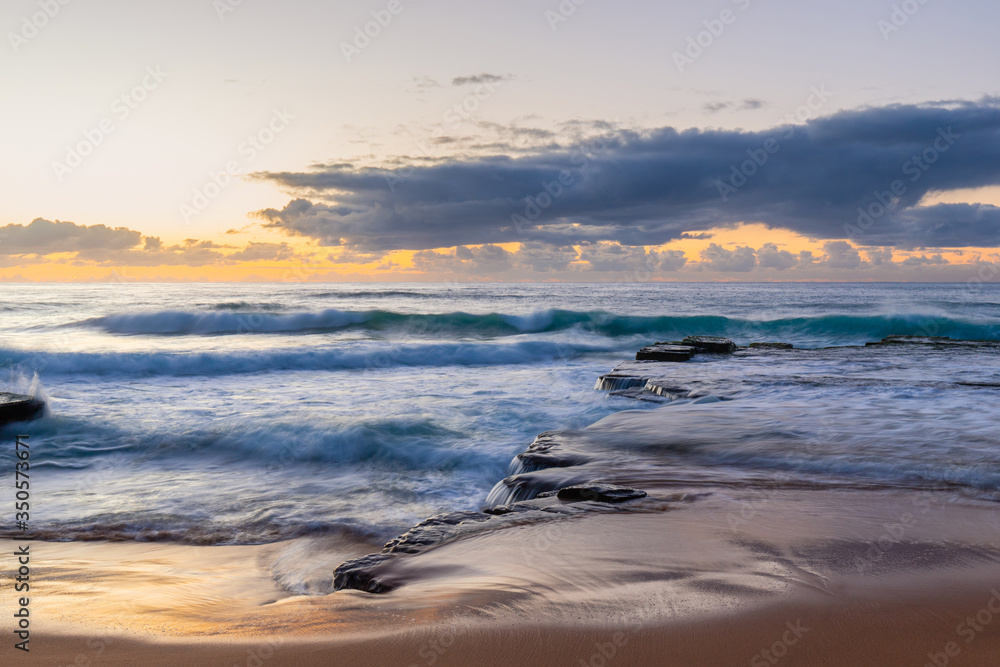 Fototapeta premium Flow of water in the rock coastline under cloudy sky at Turimetta Beach, Sydney, Australia.