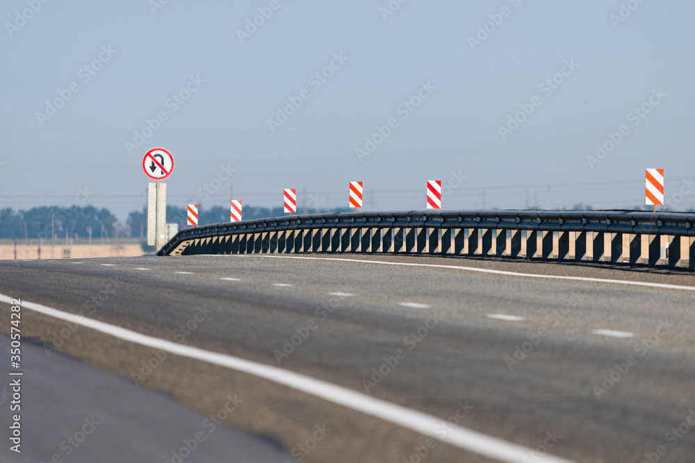 A metal separator of directions on an asphalt road between cities. Road safety