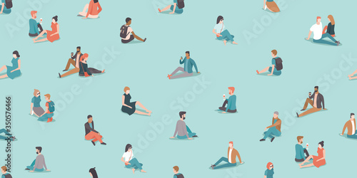 Social distancing in the park during coronavirus COVID-19 disease outbreak. People relaxing on the grass keep distance from each other.