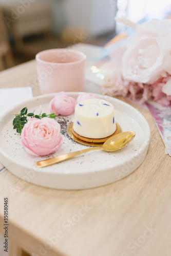 Cake with lavender on a plate and floral decoration. Flat lay. Beautiful composition with dessert. Coffee shop concept.