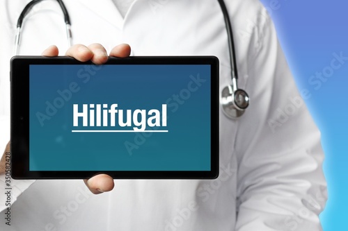 Hilifugal. Arzt mit Stethoskop hält Tablet-Computer in Hand. Text im Display. Blauer Hintergrund. Krankheit, Gesundheit, Medizin photo