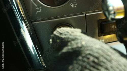 Woman plugs in a pump to a cigarette lighter after changing a car wheel