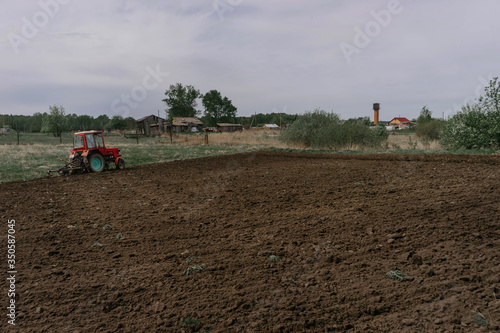 Before planting potatoes, a tractor plows the land in the village on a may day | KOROVYAKOVA, SVERDLOVSKAYA OBLAST - 9 MAY 2020.