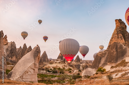 Hot air balloons flying over the famous landscape of Cappadocia, Turkey