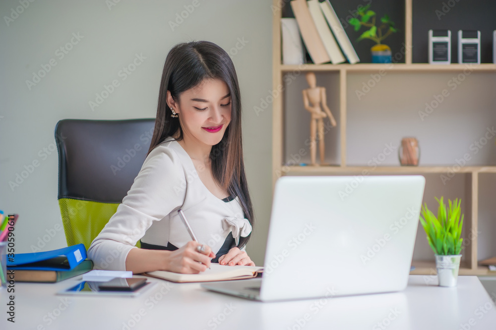 Beautiful Asian businesswoman working with a laptop in the office Beautiful Asian businesswoman working with a laptop in the office