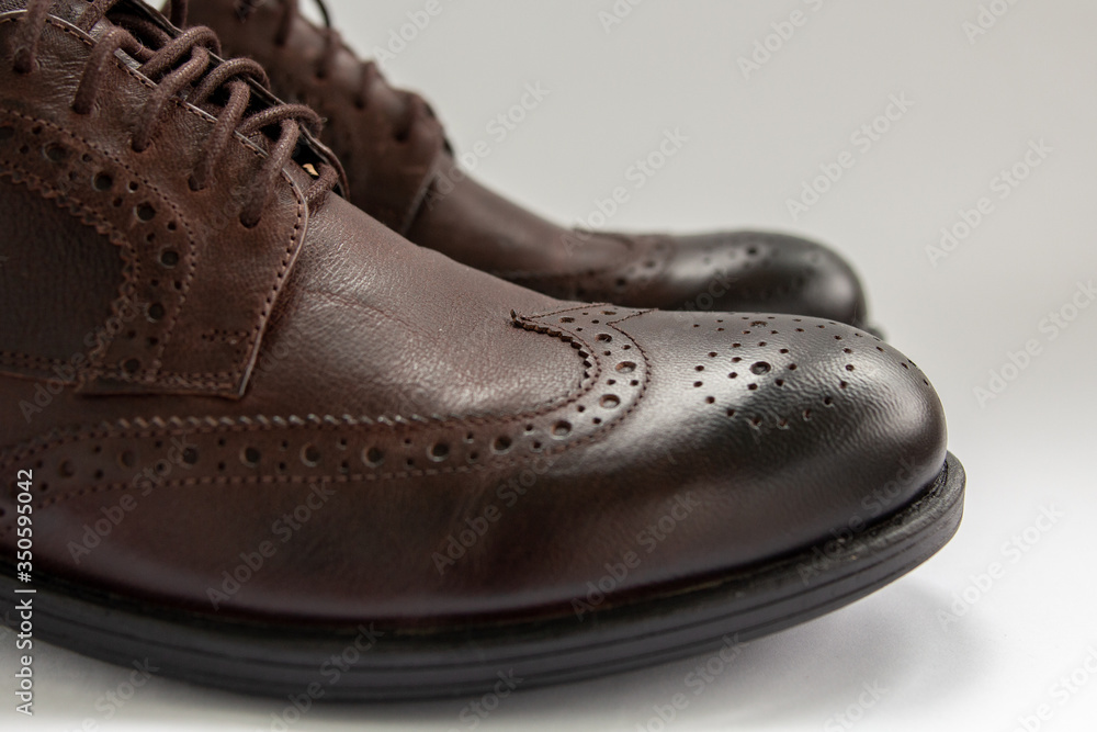 brown men’s shoes on a white background