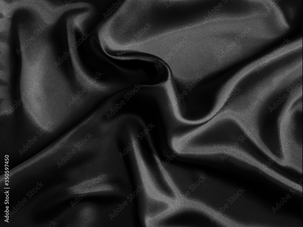 Fototapeta premium Black glossy crumpled fabric. Wavy fluid background