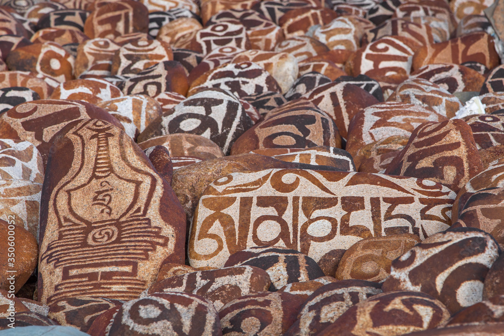 Mani stones with buddhist mantra Om Mani Padme Hum engraved in Tibetan near holy lake Manasarovar in Tibet, China
