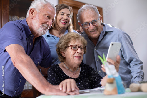 Photos Gruppo famigliare di nonni  felici che fanno una videochiamata verso persone car