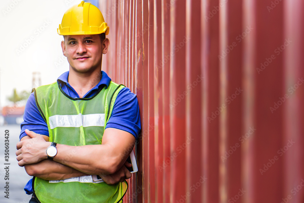 Young confident Caucasian man engineer using digital tablet and wearing yellow safety helmet and check for control loading containers box from Cargo freight ship for import and export, transport. Young confident Caucasian man engineer using digital tablet and wearing yellow safety helmet and check for control loading containers box from Cargo freight ship for import and export, transport.
