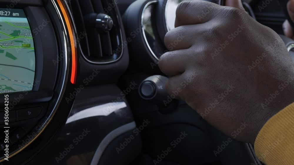 A close up shot of a black man using his indicator signal , light in his car A close up shot of a black man using his indicator signal , light in his car