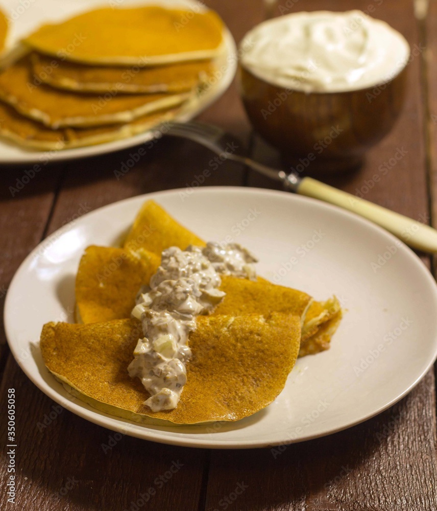 Pancakes with mushroom salad and sour cream on a plate Pancakes with mushroom salad and sour cream on a plate
