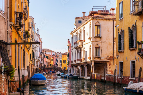 Canal and its colorful facades and boats in Venice in Veneto, Italy © FredP