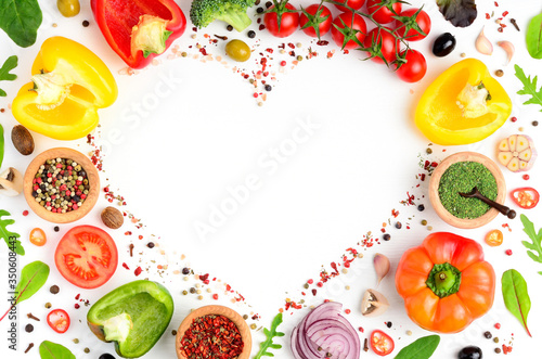 Cooking background with fresh vegetables, herbs and spices on a white kitchen table. Organic raw salad and pizza ingredients. Flat lay, copyspace, top view.