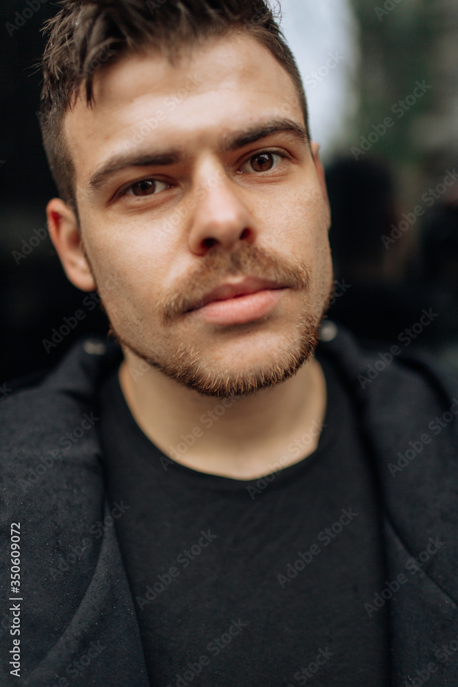 Portrait of a young man walking around the city. Brunette, beard. Cheerful, beautiful smile. Portrait of a young man walking around the city. Brunette, beard. Cheerful, beautiful smile.