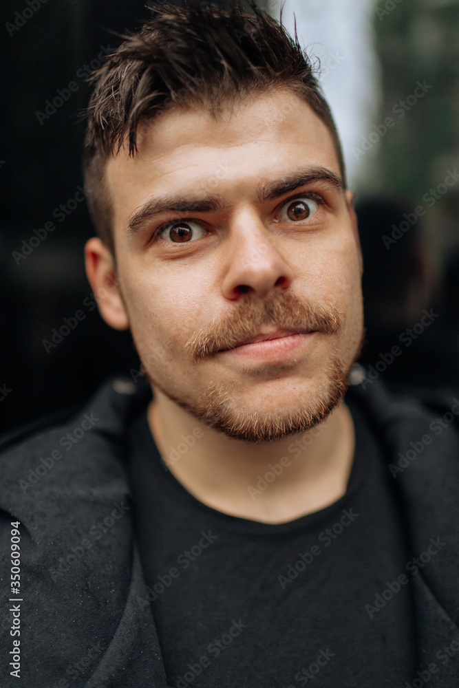 Portrait of a young man walking around the city. Brunette, beard. Cheerful, beautiful smile. Portrait of a young man walking around the city. Brunette, beard. Cheerful, beautiful smile.