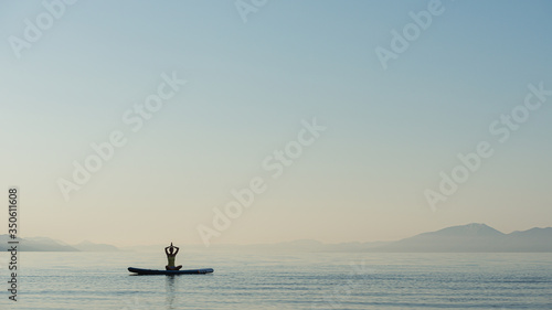 Young woman exercising on sup board