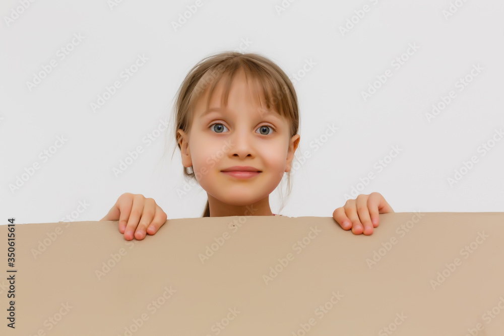 Cute little girl standing in large cardboard box, wanting to play hide-and-seek Cute little girl standing in large cardboard box, wanting to play hide-and-seek