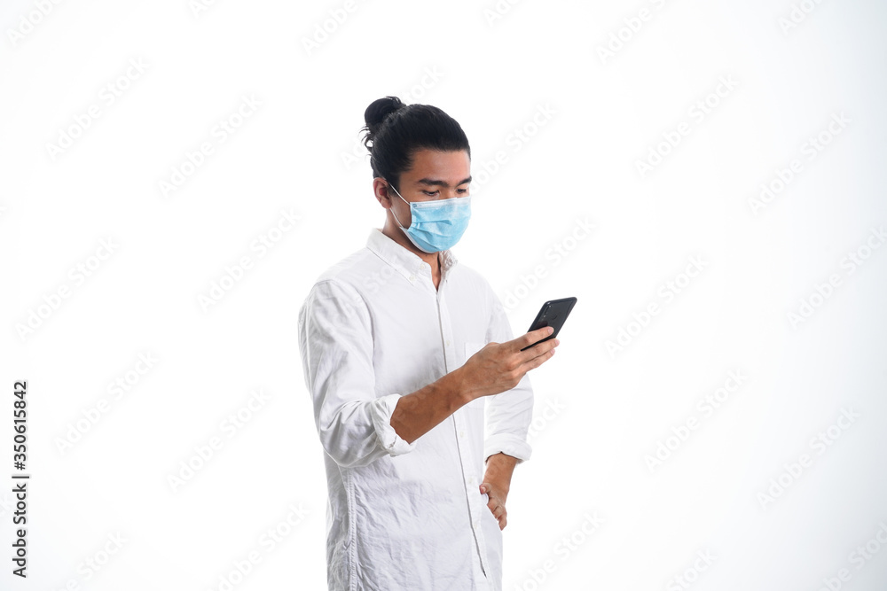 An Asian young man isolated on white background with casual entire and wearing a face mask. Hand gesture stop, sick, respect. during corona virus An Asian young man isolated on white background with casual entire and wearing a face mask. Hand gesture stop, sick, respect. during corona virus
