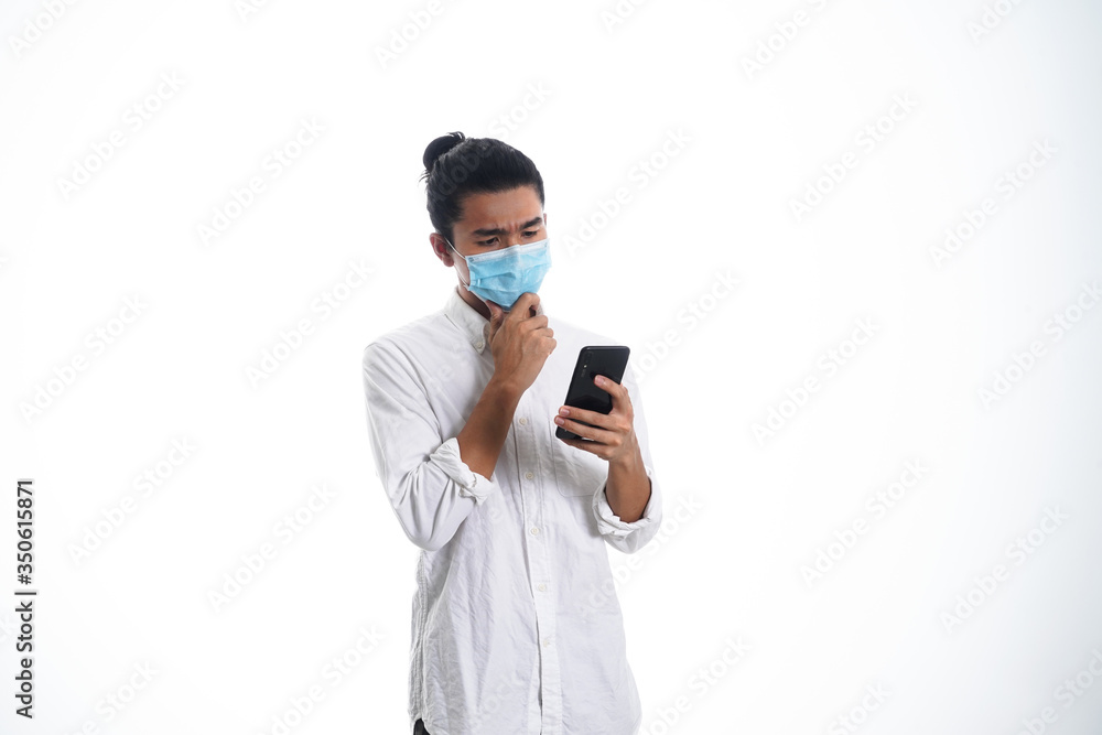 An Asian young man isolated on white background with casual entire and wearing a face mask. Hand gesture stop, sick, respect. during corona virus An Asian young man isolated on white background with casual entire and wearing a face mask. Hand gesture stop, sick, respect. during corona virus