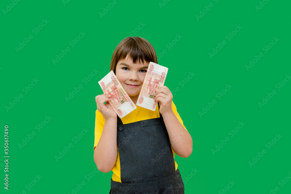 a girl of 8 years of Asian appearance holds in her hands banknotes of 5 thousand Russian rubles on an isolated background finance theme a girl of 8 years of Asian appearance holds in her hands banknotes of 5 thousand Russian rubles on an isolated background finance theme