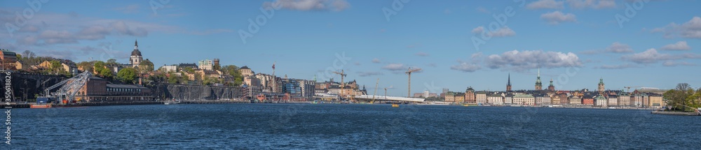 Skyline over the districts of Södermalm and the old town Gamla Stan at the sluice building with the golden bridge in Stockholm a sunny spring day.